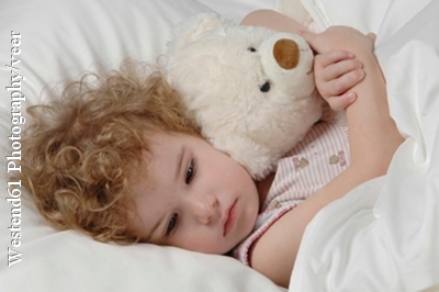 Ein Mädchen sucht Trost bei ihrem Teddy - eine Verstopfung kann sehr unangenehm sein und zu starken Bauchschmerzen führen.